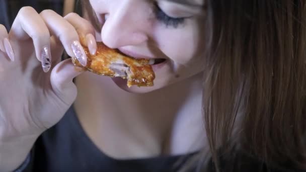 Close-up. Sexy girl eats fast food. Bites off a piece of chicken. Concept of healthy eating and obesity society — Stock Video