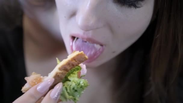Close-up. Menina sexy come fast food. Come uma sanduíche. Conceito de alimentação saudável e sociedade da obesidade — Vídeo de Stock