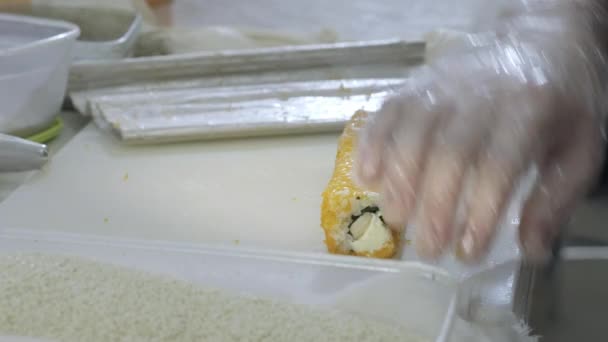 Close-up. Kook sushi koken rollen bereiden in de keuken. Draait de rijst en nori, snijdt het werkstuk. Maakt gebruik van Japanse gereedschappen. — Stockvideo