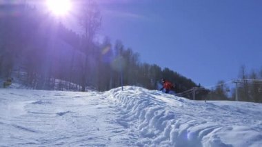 Ağır çekim: güneşli kışın kamerayı halfpipe duvar içine kar püskürtme büyük dağ kar Park, yarım boru sürme genç pro snowboard. Aşırı snowboard snowboard ve yapan.