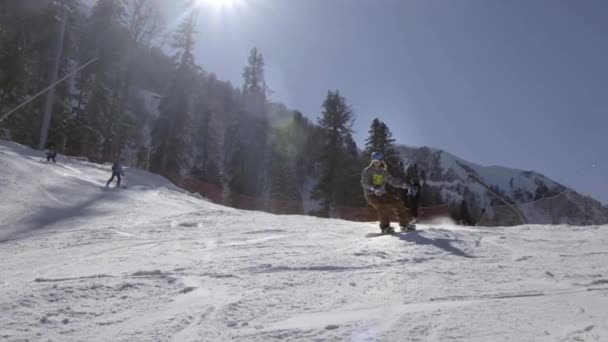SOCHI RUSSIA - 15.02.2019: Un snowboarder conquista las laderas de las montañas, una vista muy hermosa de los picos de las montañas, todo en la nieve, un cielo azul claro y soleado . — Vídeos de Stock