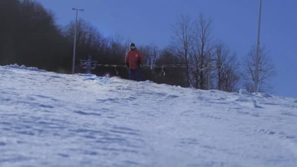 MOCIÓN LENTA CERRAR: Tallado snowboarder en nieve perfectamente arreglada en estación de esquí de montaña — Vídeos de Stock