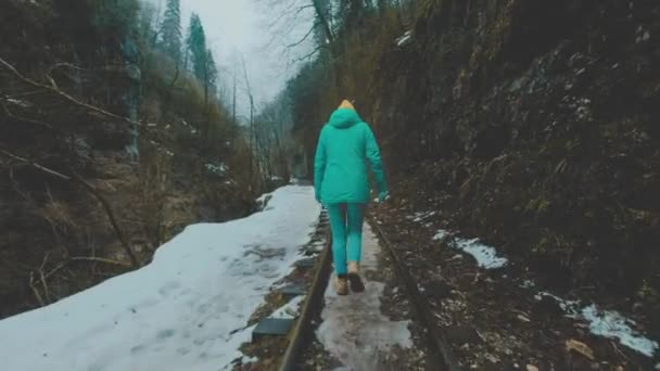 Dziewczyna podróżnik idzie wzdłuż wąskotorowa kolej. Aby poznać przygody. W ponury wąwóz górski. — Wideo stockowe