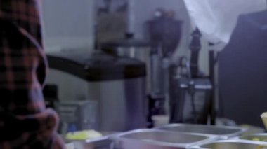 Aşçı, patates kızartması ile kaynar yağlı fritöz içine düşürüyor. Ham patates için metal kutu olabilir. Fast Food restoranının mutfağı. Cips yapıyorum. Paslanmaz kase çiğ patates cips.