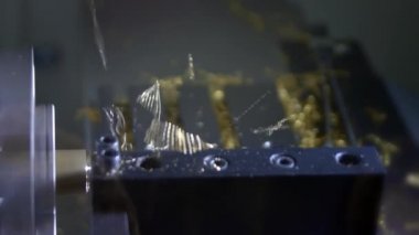 Metal işleme frezeleme makinesi. Bir fabrikada ince altın detay üretir. Metal işleme için takım tezgahları. Metal iş parçası bir elektrikli makine tarafından işlenir. Metal kıvılcımlar.