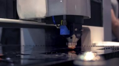 Kıvılcımlı endüstriyel lazer kesici. Programlanmış robot kafa metal sıcaklık büyük bir levha yardımı ile keser. Metal iş parçası bir elektrikli makine tarafından işlenir. Yakın çekim.