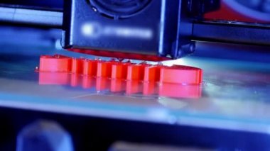 3D yazıcı yakından çalışıyor. Otomatik üç boyutlu 3D yazıcı plastik işlevi görüyor. Modern 3D yazıcı sıcak erimiş maddeden bir nesne basıyor. 3D yazdırma için yenilikçi katkı teknolojisini kavra.