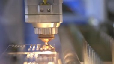 Metal inkesilmesi. Kıvılcımlar lazerden uçar. Kıvılcımlı endüstriyel lazer kesici. Programlanmış robot kafa metal sıcaklık büyük bir levha yardımı ile keser.