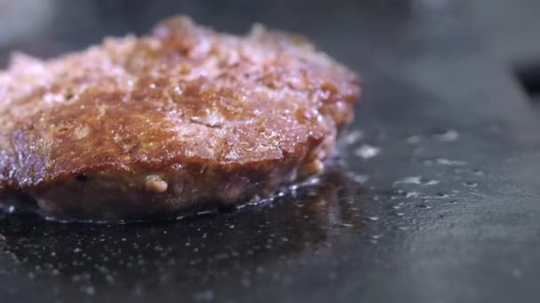 Matlagning en hamburgare, biff eller biff. På en varm spis, en pommes frites kött i ett professionellt kök. Kocken kontrollerar köttets beredskap och förvandlar köttbit över. Makro ram — Stockvideo