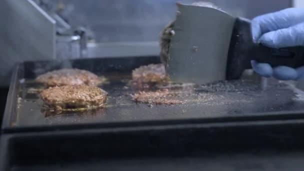 Koken van een hamburger, Patty of biefstuk. Op een warme kachel, een kok friet vlees in een professionele keuken. De kok controleert de bereidheid van het vlees en draait het stuk van vlees over. Macro kader — Stockvideo