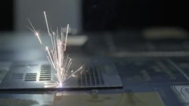 Endüstriyel lazer kesici ile kıvılcım. Metal sıcaklığı büyük bir parça yardımı ile programlanmış robot kafa keser. Yakın çekim