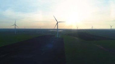 Rüzgar türbinleri günbatımı arka planında. Döngü. Ukrayna, Kırım 'da alternatif yenilenebilir enerji üretimi. Çevreyi ve doğayı önemsemek. Yeni enerji teknolojileri