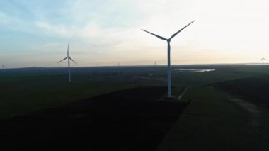 Rüzgar türbinleri günbatımı arka planında. Döngü. Rusya, Kırım 'da alternatif yenilenebilir enerji üretimi. Çevreyi ve doğayı önemsemek. Yeni enerji teknolojileri.