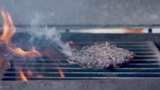 Hamburger pişirmek. Izgara üzerinde Sığır veya domuz pirzolası ızgara. Cook adam ızgara bir burger köftesi hazırlanıyor. Izgara üzerine koydu ve overturned flatware. Aile yaz tatili. Yavaş çekim — Stok video