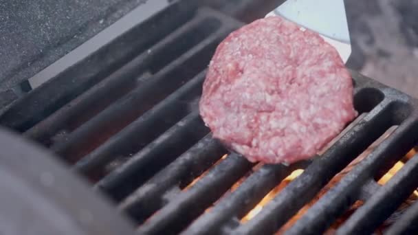 Cocinar hamburguesa. Carne de res o chuleta de cerdo a la parrilla en rejilla. Cocinero preparando una hamburguesa a la parrilla. Se acostó en la parrilla y volcó la vajilla. Vacaciones familiares de verano. Movimiento lento — Vídeos de Stock