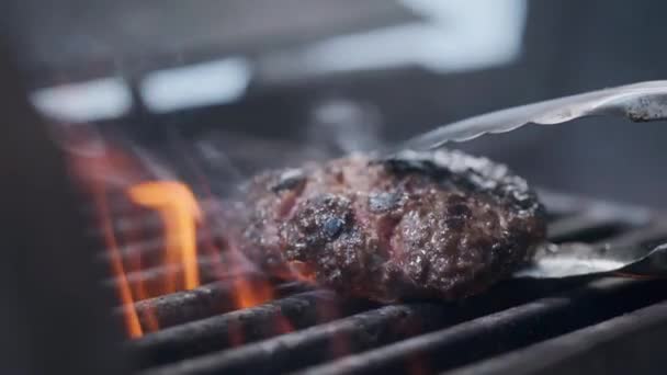 Cocinar hamburguesa. Carne de res o chuleta de cerdo a la parrilla en rejilla. Cocinero preparando una hamburguesa a la parrilla. Se acostó en la parrilla y volcó la vajilla. Vacaciones familiares de verano. Movimiento lento — Vídeos de Stock