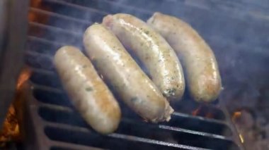 Cook ızgara sulu taze sosis hazırlanması. Ateşte kızartın. Aile yaz tatili. Close.