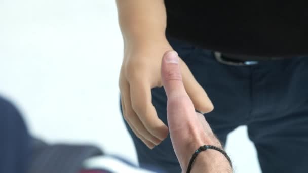 Una persona disabile senza una mano con una protesi stringe la mano a un partner d'affari. Stretta di mano protesi sullo sfondo bianco. Vita piena con una protesi . — Video Stock