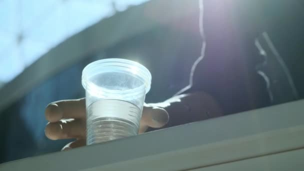 Una persona con discapacidad toma un vaso de agua de plástico. Un brazo protésico levanta un vaso de agua. Vida plena independiente con prótesis. vista inferior — Vídeos de Stock