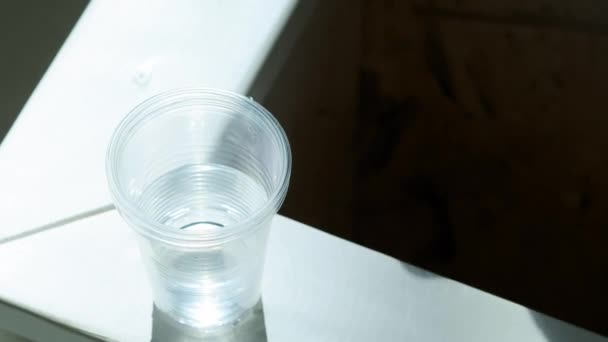 Een gehandicapte persoon neemt een plastic glas water. Een prothetische arm verhoogt een glas water. Zelfstandig volledig leven met een prothese — Stockvideo