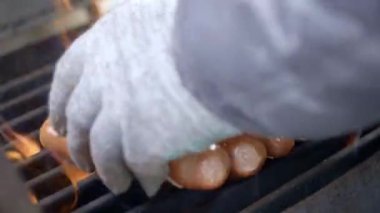 Cook ızgara sulu taze sosis hazırlanması. Ateşte kızartın. Aile yaz tatili. Close.