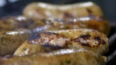 Cook ızgara sulu taze sosis hazırlanması. Ateşte kızartın. Aile yaz tatili. Close.