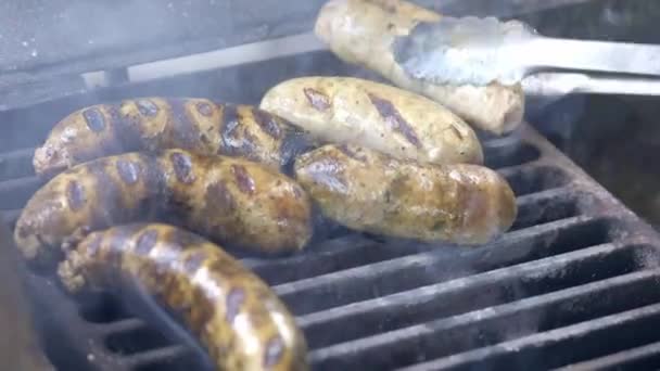 Cook preparing juicy fresh sausages grilled. Roast on fire. Family summer vacation. Close-up. — Stock Video