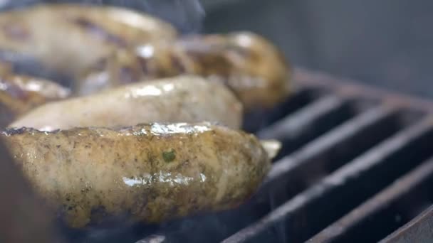 Cook připravuje šťavnaté čerstvé klobásy. Opékané v ohni. Rodinné letní prázdniny. Close-up. — Stock video