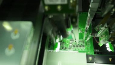 Elektronik devre kartlarının imalatı. Bilgisayar teknolojisinin en son yenilikçi üretimi. Üretim hattındaki makine mikroçipleri mikrodevre üzerine yerlebir eder..
