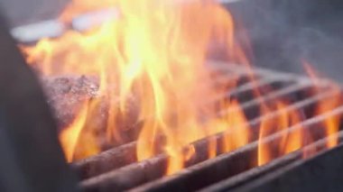 Hamburger pişirmek. Izgara üzerinde Sığır veya domuz pirzolası ızgara. Cook adam ızgara bir burger köftesi hazırlanıyor. Izgara üzerine koydu ve overturned flatware. Aile yaz tatili. Yavaş çekim