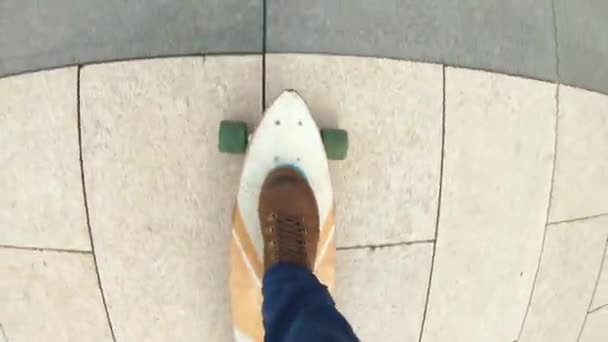 Top view handheld shot of man in travel footwear or hiking boots rides longboard on asphalt or big city. A young guy rides a longboard in the park. Urban summer fun, active lifestyle. — Stock Video