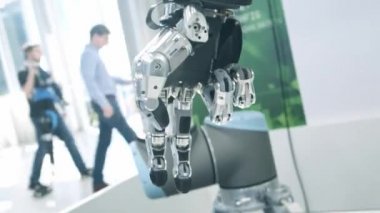 Bizim aramızda yeni teknolojiler. Robotlar el döner ve hareket eder. Parmaklarını sıkıyor ve yumrukluyor. Parlak bilimsel teknik ofis veya laboratuar.