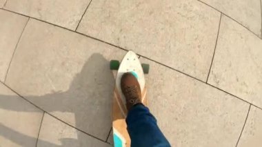 Seyahat ayakkabı veya yürüyüş botlar adam üst görünüm el çekim asfalt veya büyük şehir üzerinde Longboard sürmek. Genç bir adam parkta uzun tahta sürmek. Kentsel yaz eğlenceli, aktif yaşam tarzı.