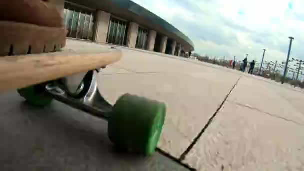 Primer plano de una rueda de longboard montada en asfalto. Primer plano skateboarder chico montar al aire libre. Un joven monta un longboard en el parque. Llevando botas de viajero. Diversión urbana de verano, estilo de vida activo — Vídeo de stock