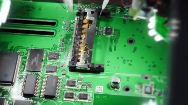 Fabrieks machine aan het werk: Printed Circuit Board wordt geassembleerd met geautomatiseerde robotarm, Oppervlaktemontage technologie die microchips aan het moederbord koppelt. Beeldmateriaal van macro close-up. — Stockvideo