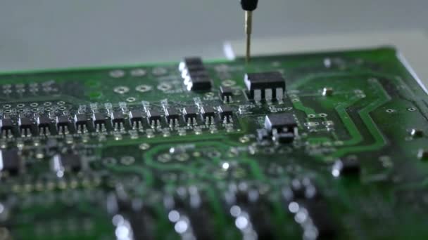 Mechanical creation process of electronic circuits. Creating an electronic board. Metal needle sets the chips on a plastic backing. Solders electronic components. — Stock Video