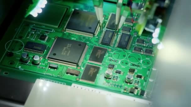 Fabrieks machine aan het werk: Printed Circuit Board wordt geassembleerd met geautomatiseerde robotarm, Oppervlaktemontage technologie die microchips aan het moederbord koppelt. Beeldmateriaal van macro close-up. — Stockvideo