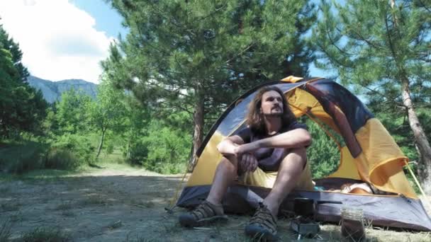 Kamp ve arkadaşlar ile seyahat yürüyüş. Bahar sabahı sahne açık, adam çadırda oturan gökyüzüne bakar, tatil hakkında düşünme gülümseme. Dostluk konsepti ve dünya turu — Stok video