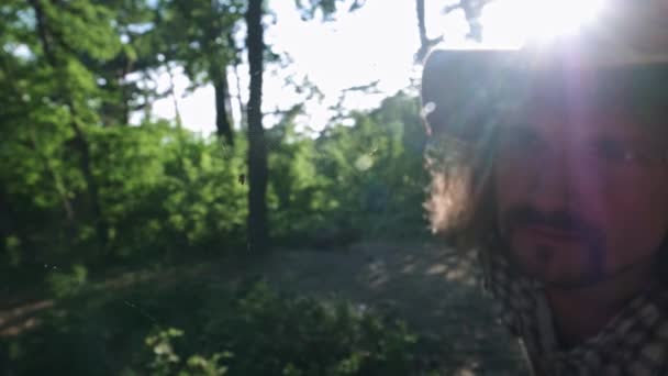 숲에서 거미를 탐험하는 젊은 남자 등산객. 큰 숲 거미입니다. 활동적인 과학적 라이프 스타일. 체크 셔츠와 여행자 모자를 착용. 하이킹 여행 컨셉 — 비디오