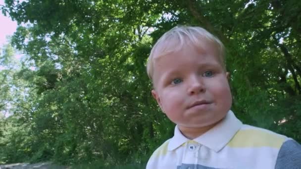 Verlies-up gezicht van een kleine jongen met blond haar dragen zonnebril. Portret van vrolijke baby in grote zonnebrillen. — Stockvideo