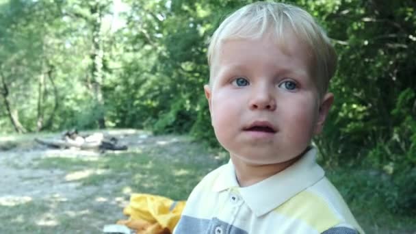 Visage perdu d'un petit garçon aux cheveux blonds portant des lunettes de soleil. Portrait de bébé joyeux dans de grandes lunettes de soleil . — Video