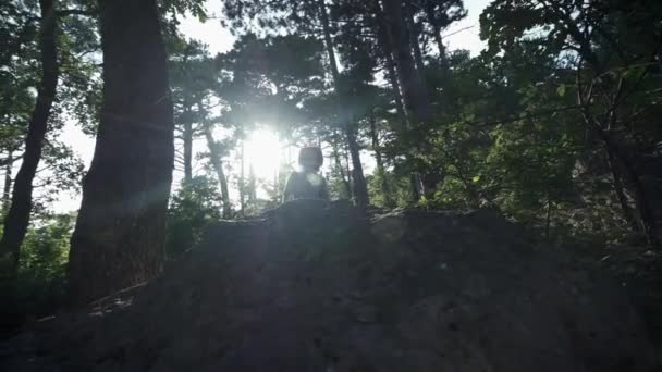 SLOW MOTION, CLOSE UP: Unrecognizable courageous male hiker climbing mountaintop, walking off trail on dangerous rocky mountain ridge. Steep wall opening beautiful view on the forest. — Stock Video