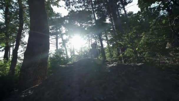 Slow Motion, close-up: onherkenbaar moedige mannelijke wandelaar klimmen bergtop, wandelen Off Trail op gevaarlijke Rocky Mountain Ridge. Steile muur opening prachtig uitzicht op het bos. — Stockvideo