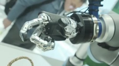 Bizim aramızda yeni teknolojiler. Robotlar el döner ve hareket eder. Parmaklarını sıkıyor ve yumrukluyor. Parlak bilimsel teknik ofis veya laboratuar.