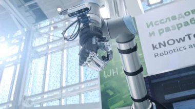 Bizim aramızda yeni teknolojiler. Robotlar el döner ve hareket eder. Avuç içi yumruk içine sıkılmış. Parlak bilimsel teknik ofis veya laboratuar.