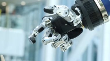 Bizim aramızda yeni teknolojiler. Robotlar el döner ve hareket eder. Parmaklarını sıkıyor ve yumrukluyor. Parlak bilimsel teknik ofis veya laboratuar.