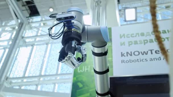 Neue Technologien unter uns. die Roboterhand dreht und bewegt sich. drückt und presst die Finger zusammen. helles wissenschaftlich-technisches Büro oder Labor. — Stockvideo