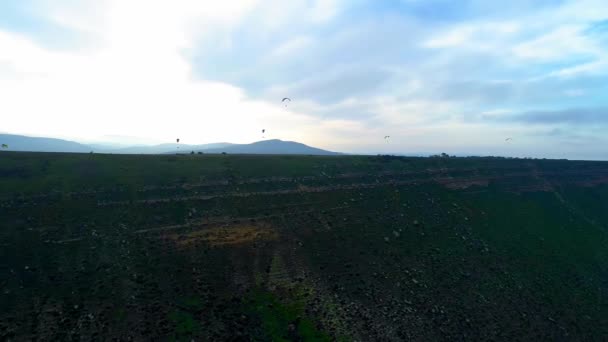 滑翔伞在滑翔伞极限运动比赛中飞越令人惊叹的山脉。滑翔伞在日落时在山上飞行 — 图库视频影像