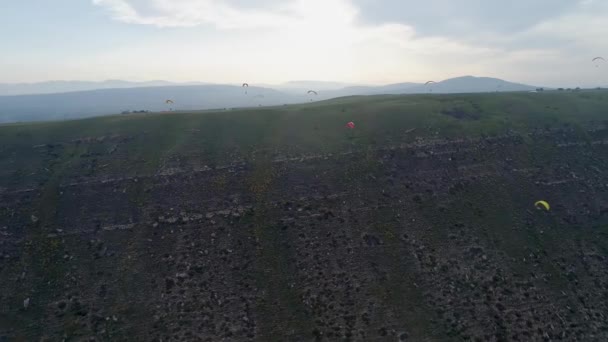 Paragliders vliegen over verbazingwekkende bergketen tijdens paragliding extreme sportcompetitie. Paragliders vliegen in de bergen tijdens zonsondergang — Stockvideo