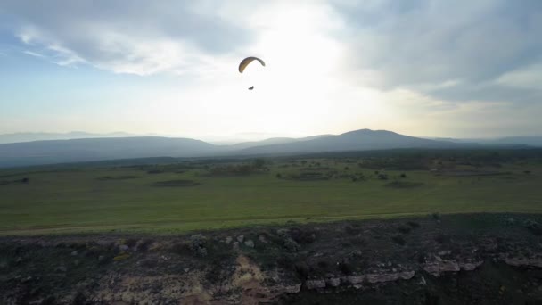 Paragliders vliegen over verbazingwekkende bergketen tijdens paragliding extreme sportcompetitie. Paragliders vliegen in de bergen tijdens zonsondergang — Stockvideo